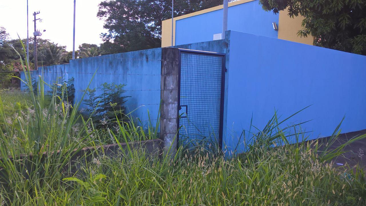 Terreno baldio tem mato e sujeira ao lado de UBS