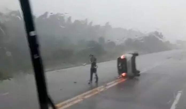 Condutor perde controle em rodovia molhada, carro capota e para no meio da pista