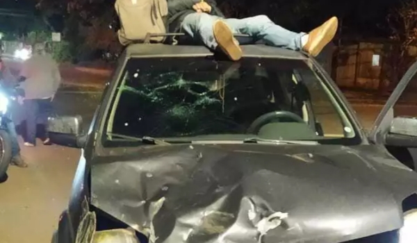 Motorista atinge moto, tenta fugir com vítima no teto do carro e acaba preso