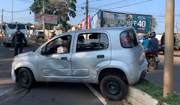 Veículo de passeio para em cima de canteiro após acidente com carro forte